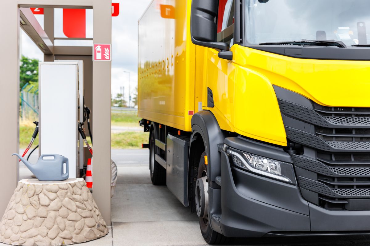 Żółta ciężarówka elektryczna na stacji ładowania ciężarówek elektrycznych.