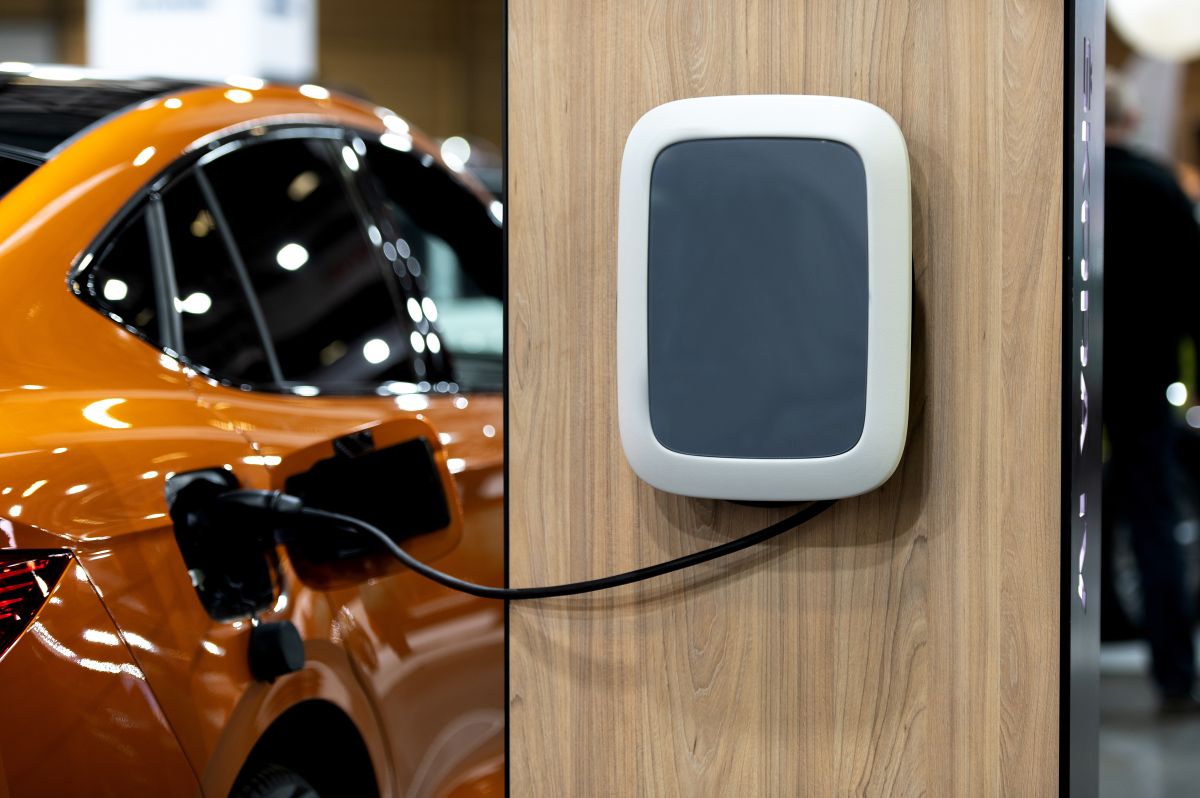 Samochód elektryczny podłączony do urządzenia na stacji ładowania samochodów elektrycznych.