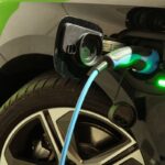 Samochód elektryczny podłączony do stacji ładowania ilustruje nowoczesne systemy ładowania samochodów elektrycznych.