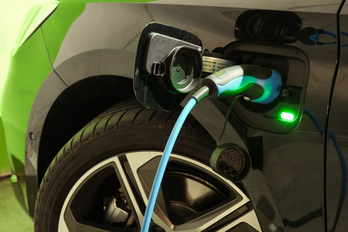 Samochód elektryczny podłączony do stacji ładowania ilustruje nowoczesne systemy ładowania samochodów elektrycznych.